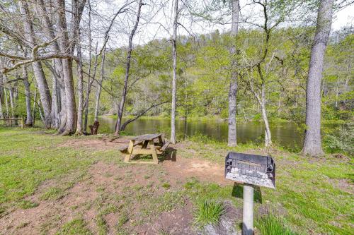 a picnic table in a park next to a lake at Hike and Fish Marlinton Cabin with Fire Pit and Views! in Marlinton