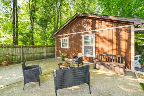 a small cabin with chairs and a table in front of it at Home with Hot Tub, Playset and Grills in Clarksville! in Clarksville