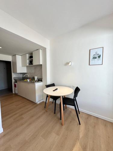 a table and chairs in a room with a kitchen at Torrar Suites in Buenos Aires