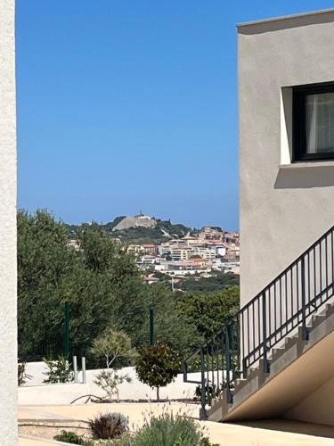 a view of a building with a hill in the background at T2 dans une résidence neuve avec piscine in Calvi