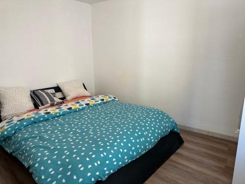 une chambre avec un lit avec des draps bleus et blancs dans l'établissement Jolie appartement F2 centre ville Bourges, à Bourges