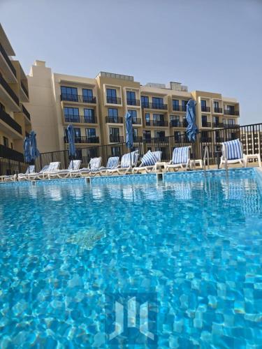 a swimming pool at a resort with chairs and a building at Sapphire holiday homes in Ras al Khaimah