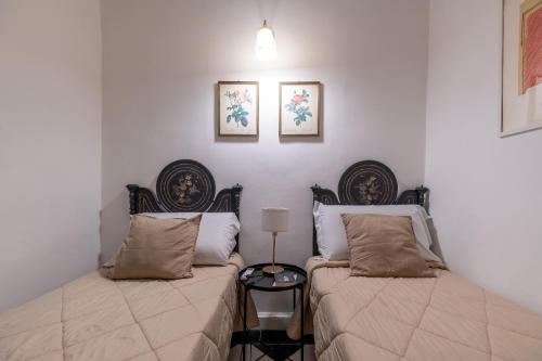 a bedroom with two beds and a lamp at Milonghita Apartment Ortigia in Siracusa