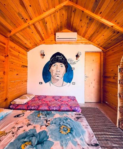a room with a bed with a painting on the wall at sea horse in Nuweiba