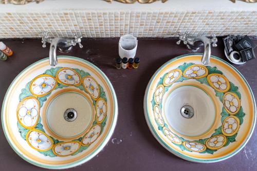 two plates on a sink on a counter at Milonghita Apartment Ortigia in Siracusa