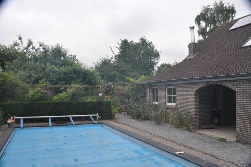 a swimming pool in a yard next to a house at De Hoge Peel in Heythuysen