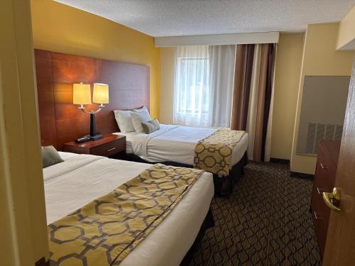 a hotel room with two beds and a window at Baymont by Wyndham Mishawaka South Bend Area in Mishawaka