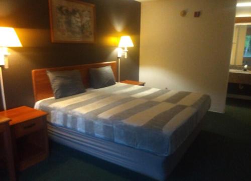 a bedroom with a bed with two pillows and two lamps at 2 Double Beds Hotel Studio 134 in Livingston