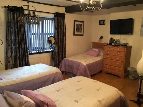 En eller flere senge i et værelse på Smithy lodge Guest House