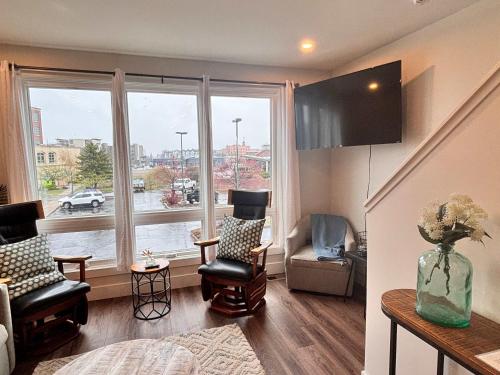 トラバースシティにあるDowntown Condo with roof patioの椅子と大きな窓のあるリビングルーム