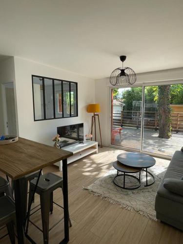 un salon avec une table et un canapé dans l'établissement Jolie dépendance au fond du jardin, à Bruges