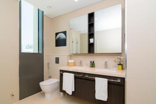 a bathroom with a toilet and a sink and a mirror at Elite Escape Holiday Home - 2 BHK Getaway with Burj Khalifa View and Dubai Mall Access - 1507 in Dubai