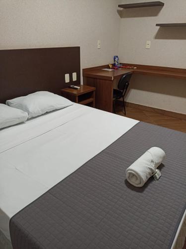 a bedroom with a bed with a towel on it at Premium Hotel Frutal in Frutal