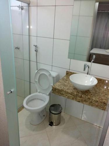 a bathroom with a white toilet and a sink at Premium Hotel Frutal in Frutal