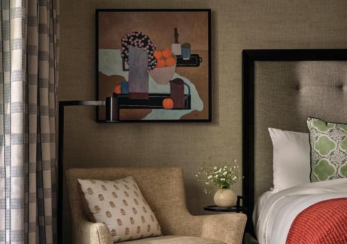 a bedroom with a bed and a chair and a painting at Ojai Valley Inn in Ojai