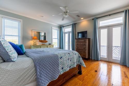 una camera da letto con un letto e un ventilatore a soffitto di Centennial Coast Cottage - with Heated pool a Saint Simons Island