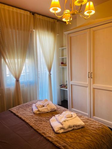 a bedroom with towels on a bed with a window at Camera luminosa per viaggiatori in Conegliano