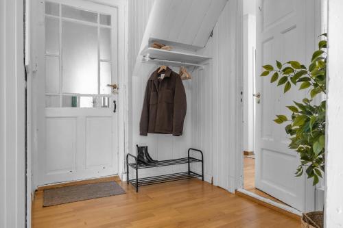 un couloir avec un manteau suspendu à une porte dans l'établissement Lovely city center apartment with amazing views and free parking!, à Tromsø