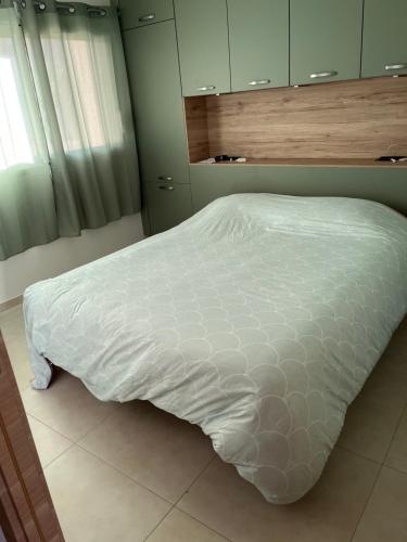 - un lit avec une couette blanche dans une chambre dans l'établissement T2 CALVI, à Calvi