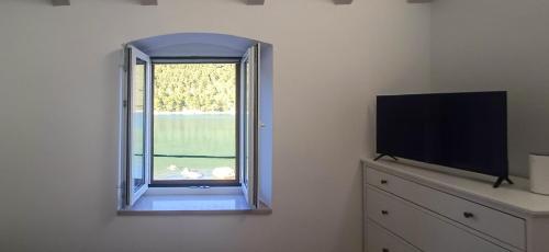 a room with a window and a tv and a dresser at Divina House 2BR 2BA beach access in Broce