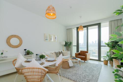 a living room with a table and chairs at Elite Escape Holiday Home - 2 BHK Getaway with Burj Khalifa View and Dubai Mall Access - 1504 in Dubai