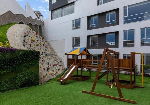 a playground with a slide and a slideintend at Departamento ideal para trabajo o turismo, cerca de Embajada A, Solca y Estadio O in Quito