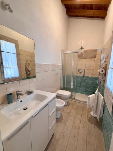 a bathroom with a sink and a toilet and a shower at BRES House in Porto Santo Stefano