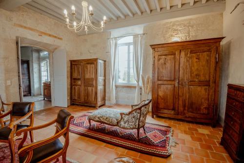 Elle comprend un salon doté d'un mobilier en bois et d'un lustre. dans l'établissement Chez Dominique 450 m2 Manoir Piscine Billard, à Saint-Martin