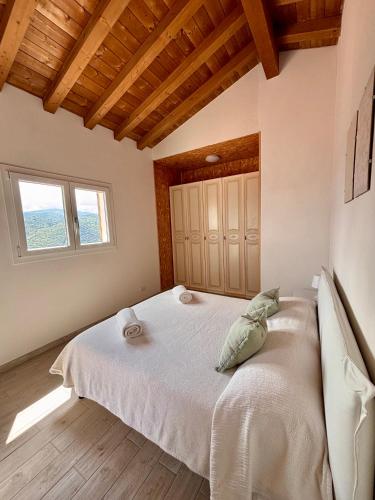 a bedroom with a bed in a room with wooden ceilings at BRES House in Porto Santo Stefano