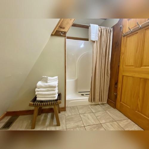 a bathroom with a shower and a pile of towels at A-Frame #02 - by The Chalets in Logan