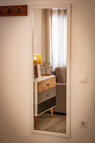 a mirror reflecting a room with a table and a couch at Skiathos Pearl in Skiathos Town