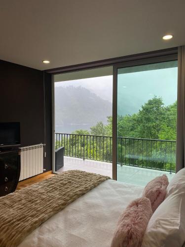 ein Schlafzimmer mit einem großen Bett und einem großen Fenster in der Unterkunft Villa Natura in Cova