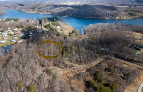 an aerial view of a house on a hill next to a lake at Aspen - by The Chalets in Logan