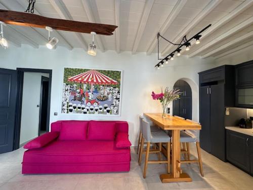 a living room with a pink couch and a table at Memories in Ornos