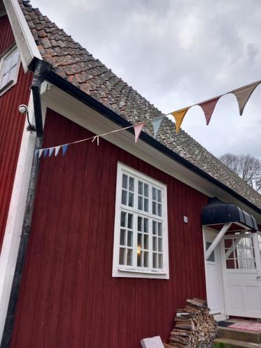 a red house with a white window and a flag at Ferienhaus Loft in Küstennähe in Ruda