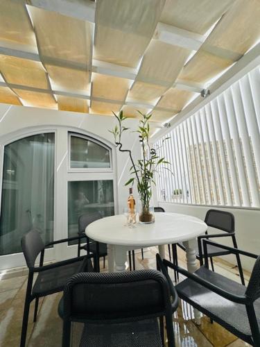 a dining room with a white table and chairs at Memories in Ornos