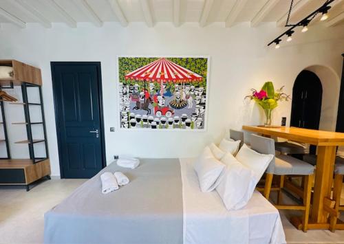 a room with a bed and a table and a painting at Memories in Ornos