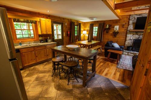a kitchen with a table and chairs in a cabin at Dogwood - by The Chalets in Logan