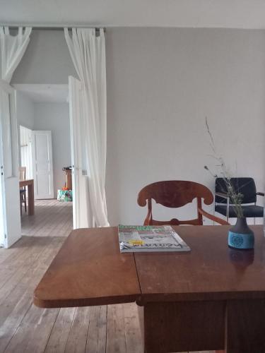 a living room with a wooden table and a chair at Ferienhaus Loft in Küstennähe in Ruda