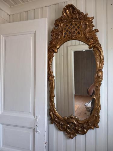 a gold mirror on a wall next to a door at Ferienhaus Loft in Küstennähe in Ruda