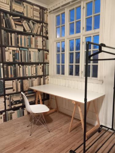 a library with a desk and a chair in front of a window at Ferienhaus Loft in Küstennähe in Ruda