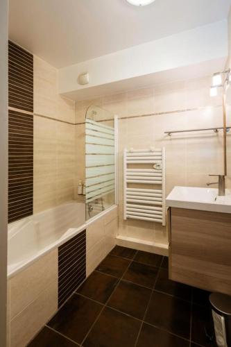 une salle de bain avec une baignoire et un lavabo dans l'établissement Les Chalets D'adrien - 3 pièces 6 personnes exposé Ouest MAE-8294, à Valloire