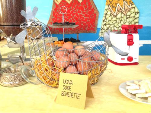 a table with a basket of food and a sign at Hotel Lux in Cesenatico