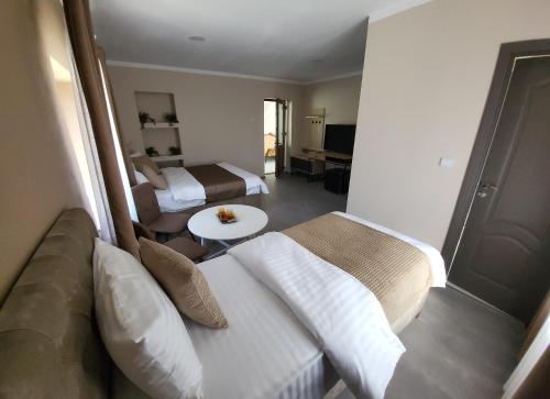 a hotel room with two beds and a couch at Pensiunea Hanul Huniazilor HD in Hunedoara