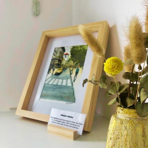 a picture frame and a vase with a flower on a table at Suíte Campo de Ourique - Art and Comfort in Lisbon