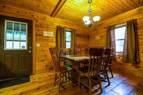 a dining room with a table and chairs in a log cabin at Oakridge - by The Chalets in South Bloomingville