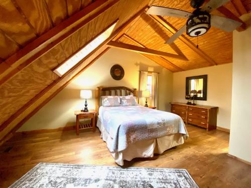 a bedroom with a large bed with a wooden ceiling at Pine Creek - by The Chalets in South Bloomingville
