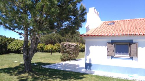 a white house with a tree in the yard at Monte Girassol - The Lisbon Country House in Quinta das Faias