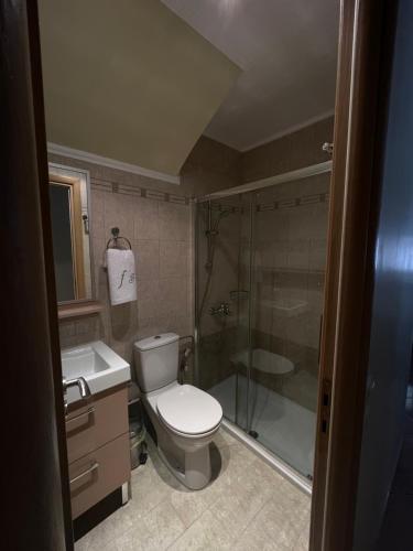 a bathroom with a toilet and a shower and a sink at AurantiaSuites in Koroni