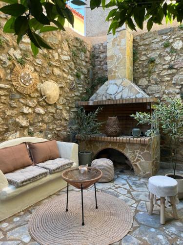 a patio with a couch and a table and a fireplace at AurantiaSuites in Koroni